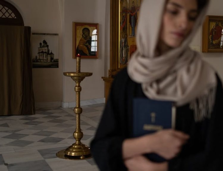 Woman with headscarf holding book in serene church setting, embodying spirituality.
